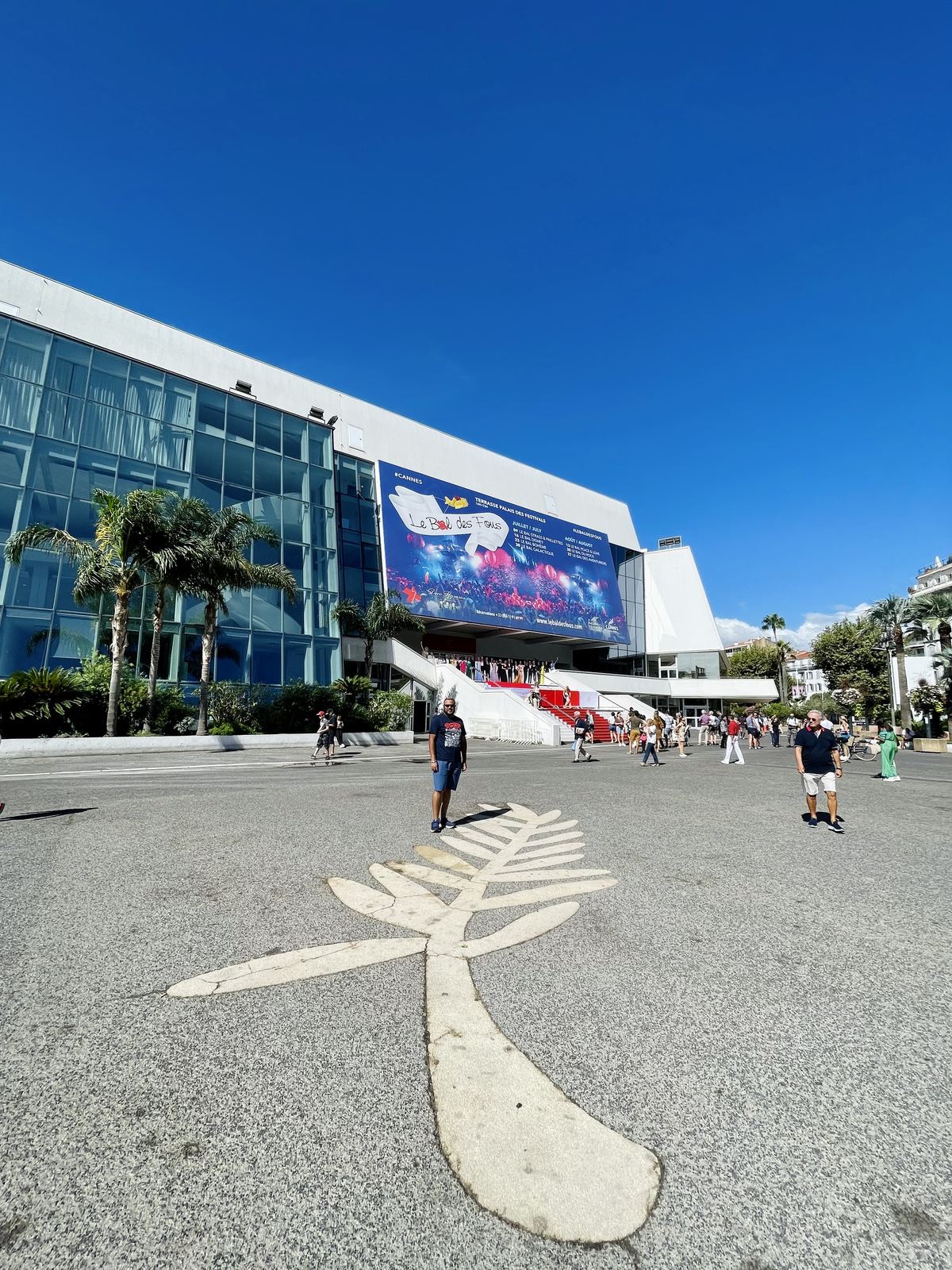Palais des Festivals — the Palme d'Or in the ground, festival banners, blue sky